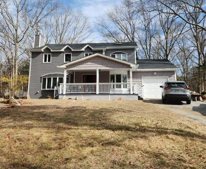 After: rebuilt two-story gray home with white porch and new roof
