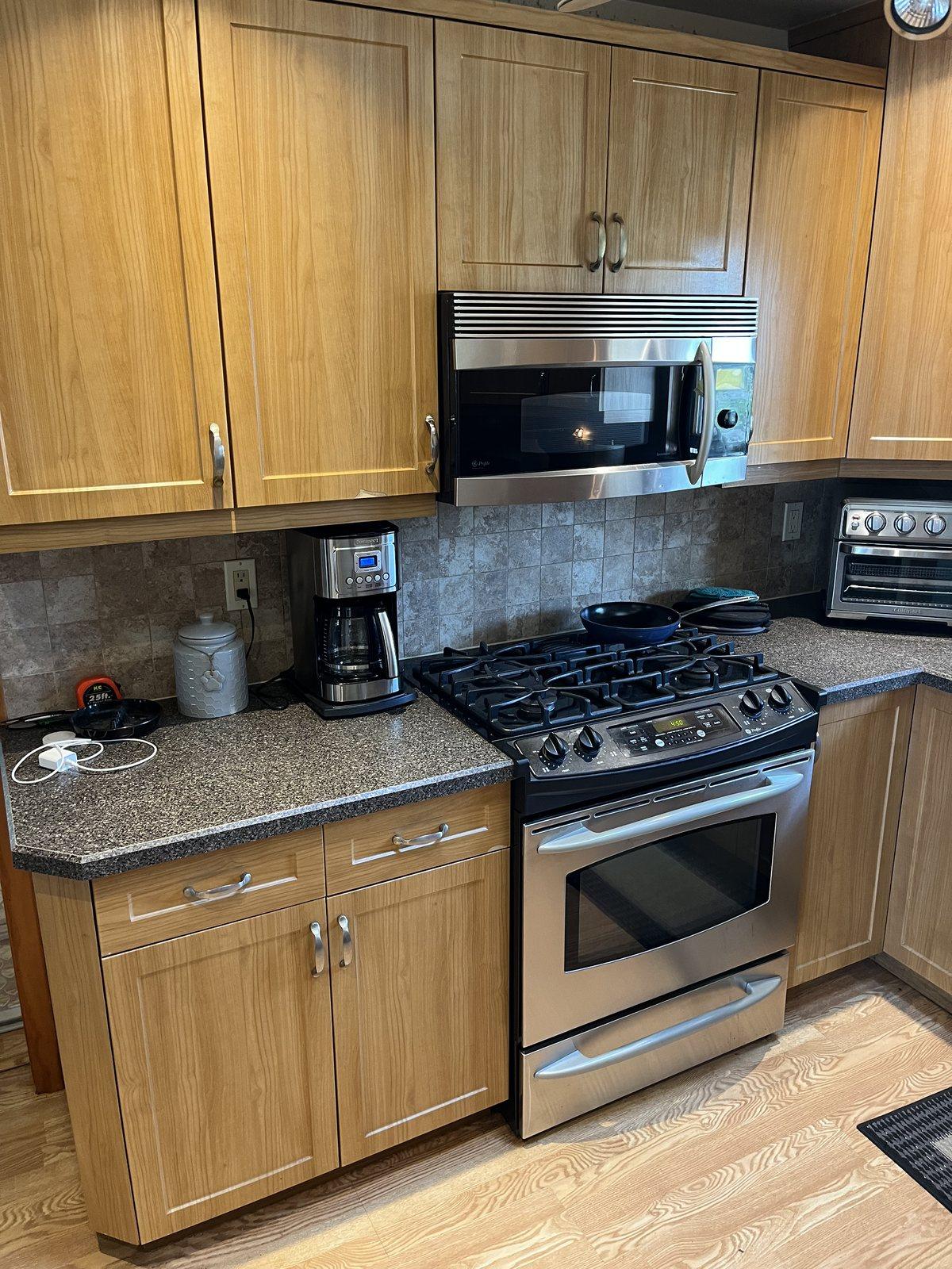 Before: Bellmore kitchen with honey oak cabinets, dark speckled laminate counters and an older stainless range