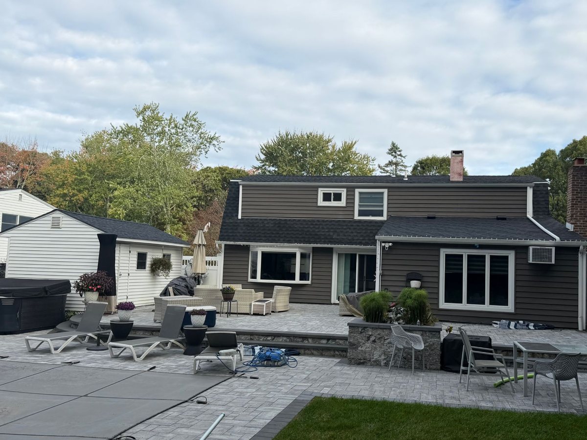 Rear of the Farmingville home with its new black shingle roof over the main house and the lower addition, and the backyard shed re-roofed in the same shingle