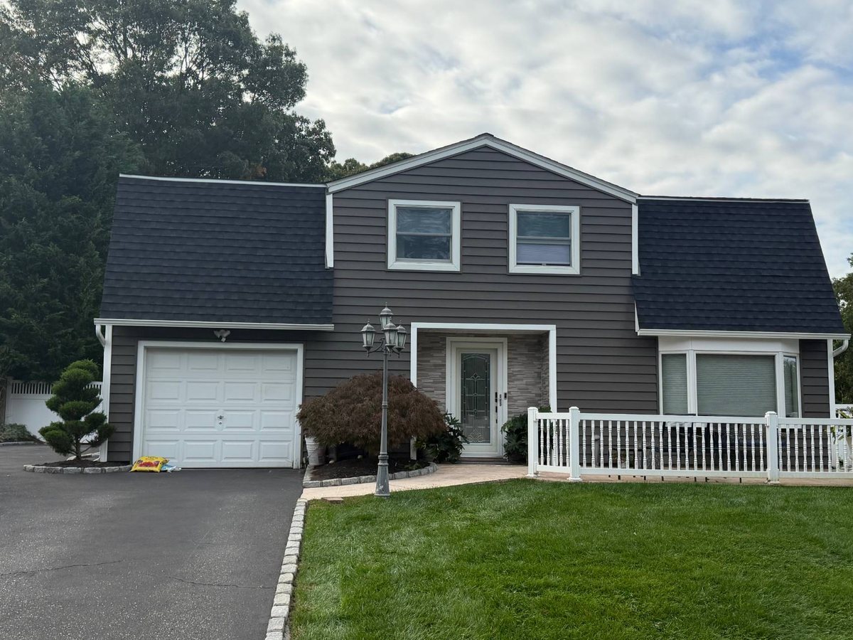 Finished job in Farmingville, NY: two-story home with brown siding and a new black architectural shingle mansard roof, October 2026