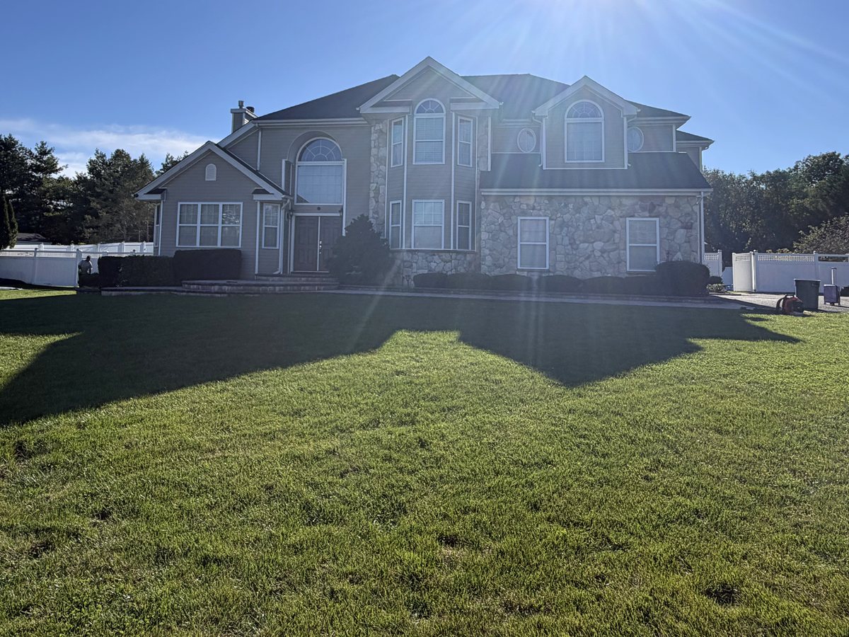 Finished job in Miller Place, NY: large two-story colonial with stone veneer, a two-story entry and a new dark grey architectural shingle roof, October 2026
